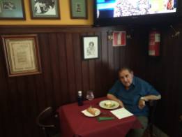 Joaquín Brotons, almorzando en la mesa que tiene reservada en el bar-restauran:"El penalty", junto a su retrato, cuyo autor es su entrañable amigo el pintor Miguel Carmona. Valdepeñas, 2019